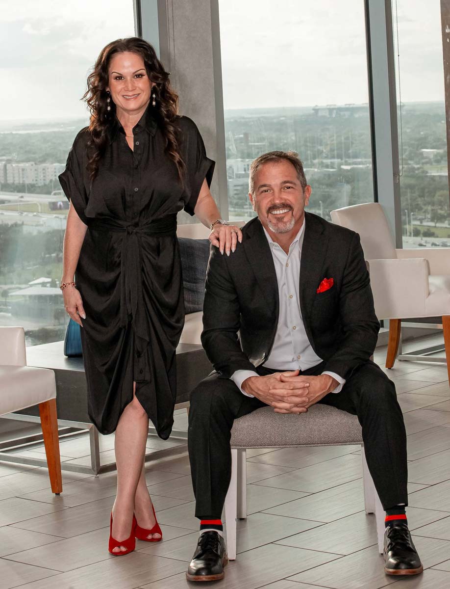 Chris and Lois from Russo Health & Life Insurance sitting together in a professional office setting in Tampa, Florida